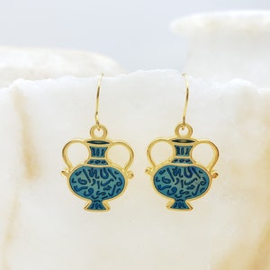 May include: Gold tone earrings with a blue and gold design of a vase with Arabic script.