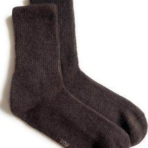 May include: A pair of dark brown socks, likely wool or a similar material, with a ribbed texture. The socks are folded and displayed against a white background. The brand name "YOK" is visible on the side of one sock.