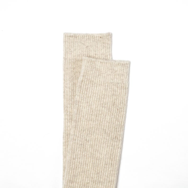 May include: A pair of beige ribbed socks. The socks are made of a soft, comfortable material and are perfect for everyday wear.
