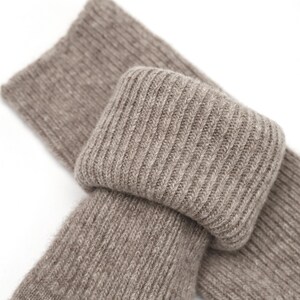May include: A pair of brown ribbed socks made of soft, cozy material. The socks are folded over, showing the ribbed texture.