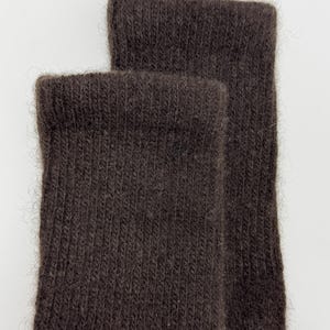 May include: Close-up of two brown socks. The socks are made of a soft, textured material, with a ribbed knit pattern. The cuffs are folded over, and the socks appear to be unworn.