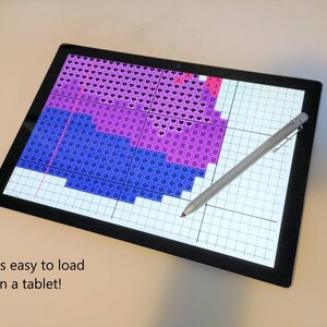 May include: A tablet screen displaying a digital cross-stitch pattern with pink, purple, and blue squares. A stylus pen is lying on the screen. The text "PDF is easy to load on a tablet!" is displayed below the screen.