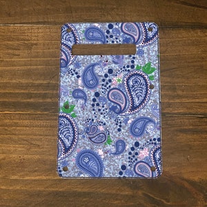 May include: A blue and white paisley patterned guitar pickguard. The pickguard is made of a clear plastic material and has a silver glitter finish.