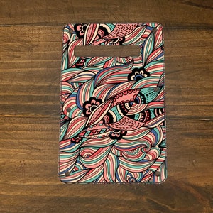 May include: A colorful guitar pickguard with a swirling, abstract pattern in shades of pink, blue, and white.