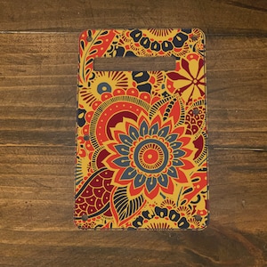 May include: A guitar pickguard with a colorful paisley pattern in shades of red, yellow, blue, and black.
