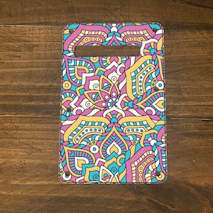 May include: A colorful guitar pickguard with a pink, yellow, blue, and white mandala design.