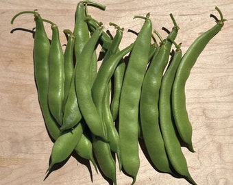 May include: A bunch of fresh green string beans, some with the ends trimmed off, arranged on a light brown wooden surface.