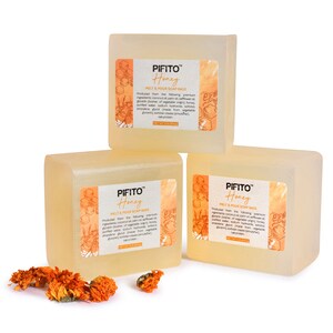 Op de afbeelding: Drie staven transparante, honingkleurige smelt- en gietzeepbasis met de tekst "PIFITO Honey Melt & Pour Soap Base" gedrukt op elke staaf. De staven zijn in een driehoekige vorm op een witte achtergrond gerangschikt.
