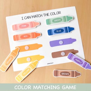 May include: A colour matching game with a white background and colourful crayon cutouts. The game includes the text "I CAN MATCH THE COLOUR" and "COLOUR MATCHING GAME". The crayons are labelled with colours like pink, red, orange, yellow, green, blue, purple, and brown.