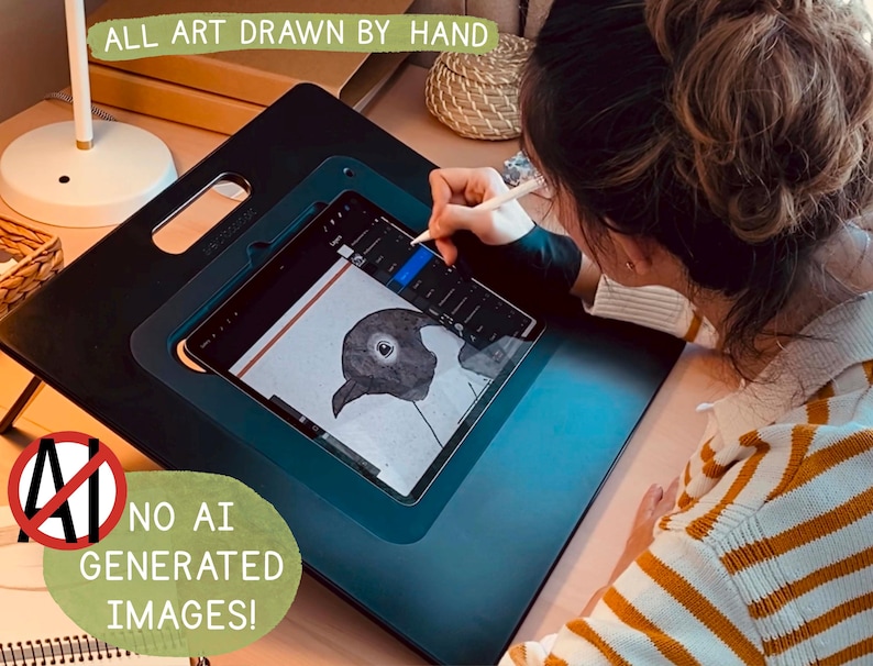 May include: A person is drawing a black and white illustration of a bird on a digital tablet. The tablet is on a black drawing board with a handle. The text "ALL ART DRAWN BY HAND" is visible at the top of the image. The text "NO AI GENERATED IMAGES!" is visible at the bottom of the image.
