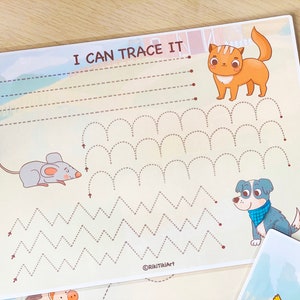 May include: A printable worksheet for kids to practice tracing lines. The worksheet features a cat, a mouse, and a dog, and includes lines to trace in the shape of waves, zigzags, and arches. The text "I can trace it" is at the top of the page.