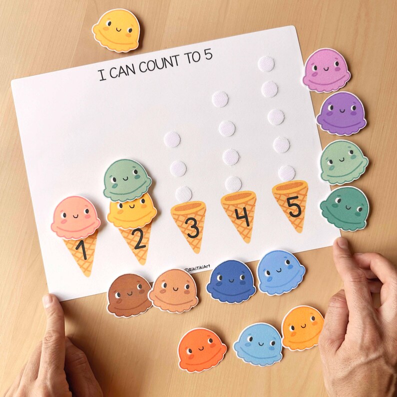 May include: A white educational board with the text "I CAN COUNT TO 5" features ice cream cone illustrations numbered 1-5. Colorful ice cream scoops are scattered around the board. The board has raised dots for tactile learning. A fun, colorful learning tool.