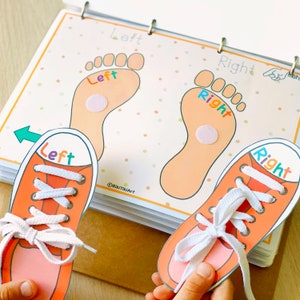May include: A learning activity for kids featuring two orange and white sneakers with laces. The sneakers are placed on top of a page with two orange footprints. The footprints are labeled "Left" and "Right" with colorful letters. The page also has a green arrow pointing to the left.