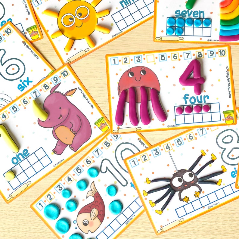 May include: A set of ten colorful educational cards featuring numbers 1 through 10. Each card has a different animal or object, such as a sun, a rhino, a jellyfish, a spider, and a fish. The cards also have a grid for counting and a rolling pin graphic.