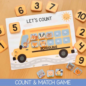 Puede incluir: Un juego de conteo con forma de autobús escolar amarillo con el texto LET'S COUNT y SCHOOLBUS. El tablero muestra un conejo conductor y fichas de animales como ardilla, tejón, ardilla listada, zorro y gato. Incluye fichas numéricas del 1 al 10.