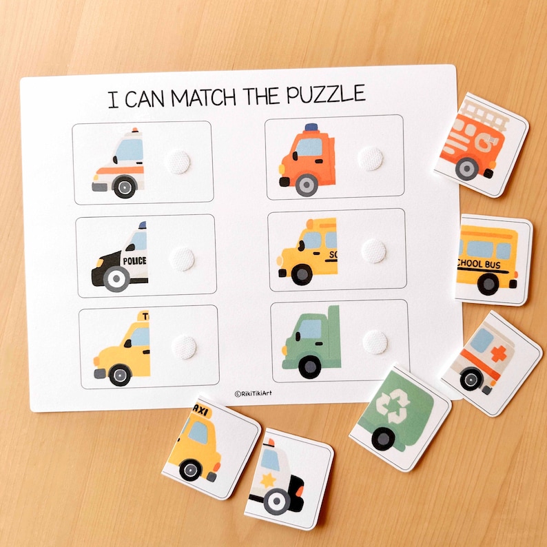 May include: A white wooden puzzle board with the text "I CAN MATCH THE PUZZLE" and illustrations of various vehicles. Includes matching puzzle pieces of a fire truck, school bus, ambulance, and more.