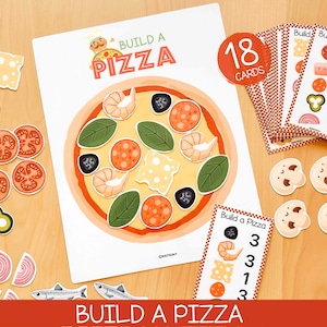 Puede incluir: Un juego educativo Build a Pizza que incluye una hoja grande con la base de una pizza, 18 tarjetas y varios ingredientes recortables como camarones, pepperoni, queso, albahaca, aceitunas, champiñones, tomates, cebollas y pescado.