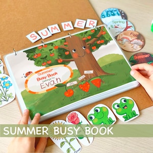 Peut inclure: Un livre d'activit&eacute;s sur le th&egrave;me de l'&eacute;t&eacute; color&eacute; avec une couverture verte repr&eacute;sentant un arbre souriant avec des cerises rouges. Le livre est ouvert sur une page avec une illustration de cerise, de fraise et de past&egrave;que. Le titre du livre est "Summer Busy Book" et le nom "Evan" est &eacute;crit sur la page. Le livre est reli&eacute; par un anneau et contient une vari&eacute;t&eacute; d'autres pages avec diff&eacute;rentes activit&eacute;s.