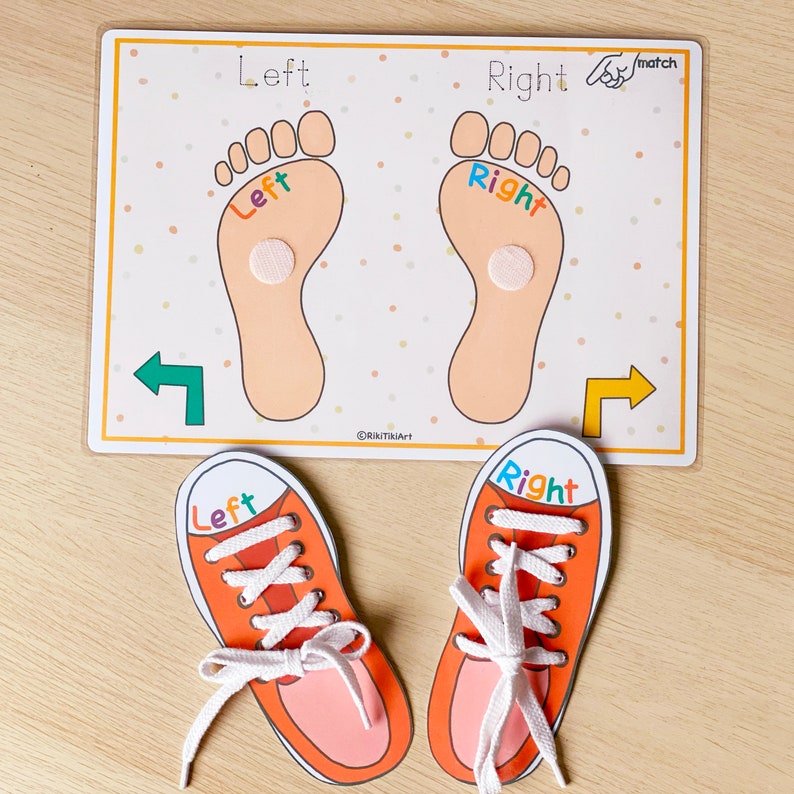 May include: A learning game for kids featuring two orange shoes with white laces and the words "Left" and "Right" on them. The shoes are placed on a white card with two orange feet with the words "Left" and "Right" on them. The card has a white background with orange polka dots.