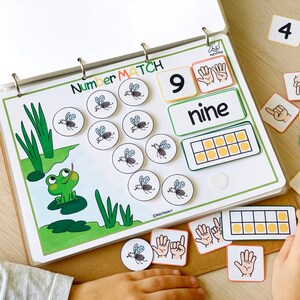 Peut inclure: Un jeu &eacute;ducatif color&eacute; pour enfants avec une grenouille, des mouches et le chiffre neuf. Le jeu comprend une carte de nombre, une carte de mot et une grille avec neuf cases. Le jeu est con&ccedil;u pour aider les enfants &agrave; apprendre &agrave; compter et &agrave; reconna&icirc;tre les nombres.