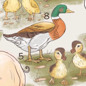 May include: A brown, white and green duck with the number 8 on its back. The duck is standing on green grass with two yellow ducklings. The ducklings are looking at the camera.