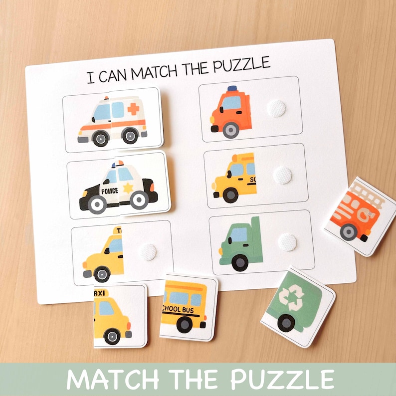 May include: A white puzzle board with the text "I CAN MATCH THE PUZZLE" and "MATCH THE PUZZLE". The puzzle features colorful illustrations of emergency vehicles, including an ambulance, police car, fire truck, taxi, school bus, and garbage truck.