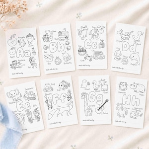 May include: A set of eight white rectangular coloring cards featuring black line art illustrations of letters A through H. Each card displays various objects and animals corresponding to the letter, with the text made with love by at the bottom.