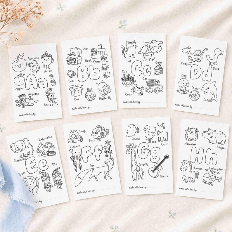 May include: A set of eight white rectangular coloring cards featuring black line art illustrations of letters A through H. Each card displays various objects and animals corresponding to the letter, with the text made with love by at the bottom.