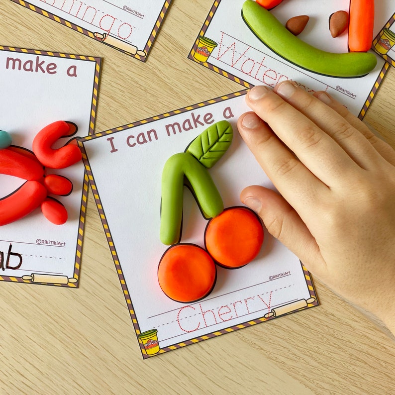 May include: A printable activity card with the text "I can make a cherry" and a picture of a red and green playdough cherry. The card has a line for writing the word "cherry" and a picture of a rolling pin.
