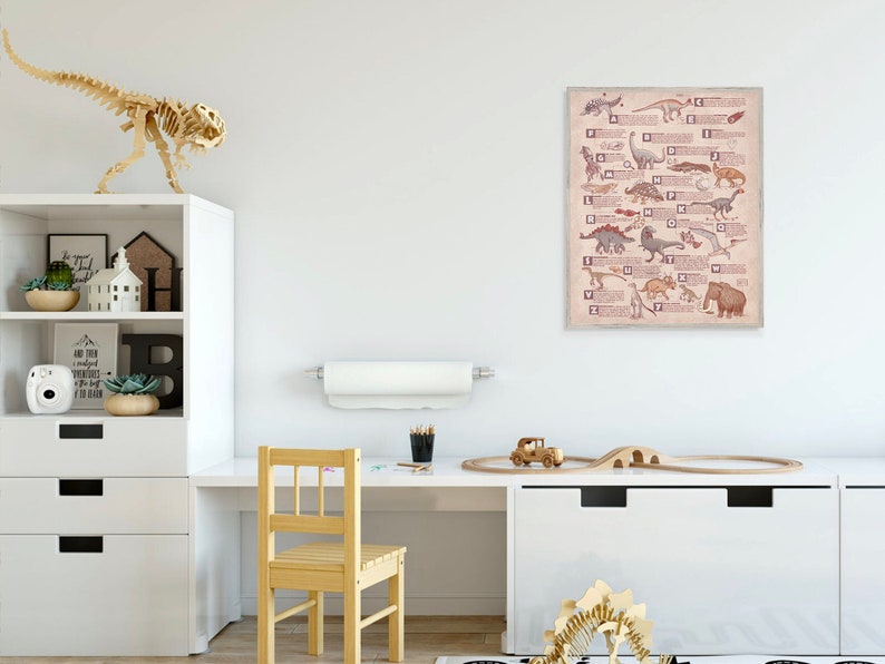 Puede incluir: Una pared blanca con un p&oacute;ster del alfabeto de los dinosaurios, una estanter&iacute;a blanca con un esqueleto de dinosaurio de madera, un escritorio blanco con una silla de madera y una v&iacute;a de tren de madera con un coche de juguete.