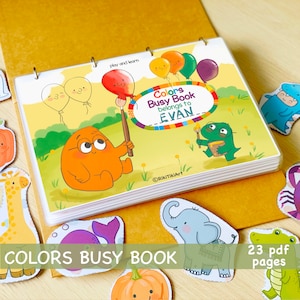 Peut inclure: Un livre d'activit&eacute;s color&eacute; pour enfants avec 23 pages. La couverture pr&eacute;sente un gentil monstre orange tenant un pinceau et un titre qui dit "Colors Busy Book belongs to EVAN".