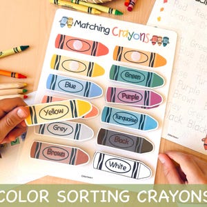 May include: A color sorting activity featuring crayon-shaped cards with color names like "Yellow," "Blue," and "Green." The image includes a matching worksheet and real crayons, promoting early childhood education and color recognition.