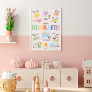 May include: A colorful poster with daily reminders for kids. The poster features illustrations of a sun, a rainbow, a butterfly, a cloud, and a flower. The text on the poster includes phrases like "Today will be a good day", "You are so loved", "You are enough", "Amazing things are coming", "You are brave", and "These feelings will pass".