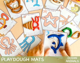 May include: Playdough mats featuring ocean animals. The mats have outlines of various sea creatures, including a crab, starfish, octopus, shark, and dolphin. The text "I can make a" is printed on each mat. The mats are designed for children to use playdough to create the shapes of the animals.