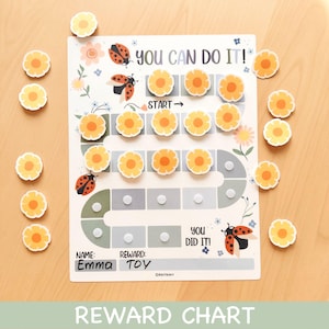 May include: A reward chart with the text "YOU CAN DO IT!" and "YOU DID IT!" features a path of flower magnets and ladybug illustrations. The chart includes spaces for a name and reward, with additional flower magnets scattered around.