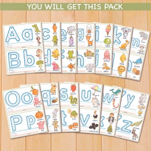 May include: A set of 26 alphabet tracing cards featuring a different animal or object for each letter. Each card has a dotted line for tracing the letter and a picture of the corresponding word below. The words are: alligator, ant, carrot, cactus, elephant, eggplant, ghost, giraffe, ice cream, iceberg, kangaroo, koala, mushroom, mouse, nut, orange, octopus, queen bee, snake, strawberry, umbrella, unicorn, whale, worm, yogurt, pumpkin, pig, robot, turtle, tiger, vampire bat, x-ray, xmas tree, zebra, zucchini.