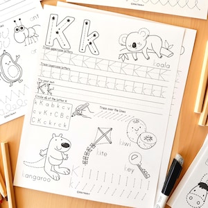 Peut inclure: Feuille de travail &eacute;ducative en noir et blanc sur la lettre "K". Elle comprend des exercices de tra&ccedil;age pour les lettres majuscules et minuscules, des illustrations de koala, kangourou, cerf-volant, kiwi et cl&eacute;, et le texte "Try your own".
