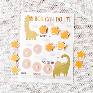 May include: A reward chart with a dinosaur theme. The chart features the text "YOU CAN DO IT!" and "YOU DID IT!" along with star-shaped stickers. The chart includes spaces for a name and reward.