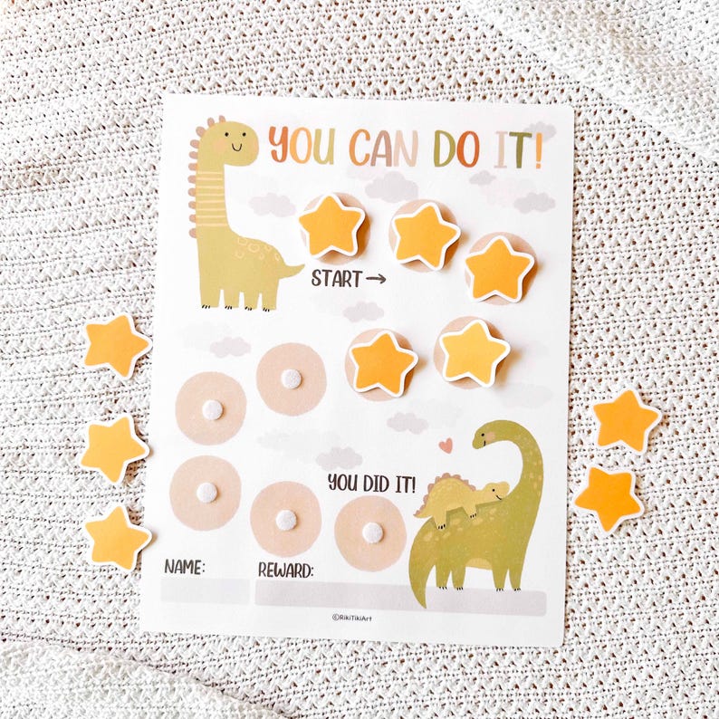 May include: A reward chart with a dinosaur theme. The chart features the text "YOU CAN DO IT!" and "YOU DID IT!" along with star-shaped stickers. The chart includes spaces for a name and reward.