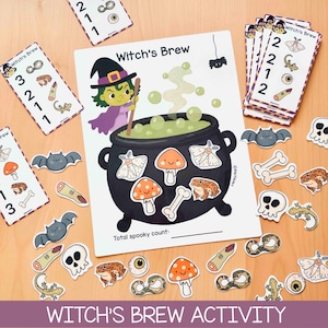 Könnte beinhalten: Ein Witch's Brew Aktivitätsset mit einer zentralen weißen Karte, die einen schwarzen Kessel, eine grüne Hexe und grüne Blasen zeigt. Das Set enthält mehrere kleine ausgeschnittene Karten mit Zahlen und Illustrationen von Pilzen, Totenköpfen und Schlangen.
