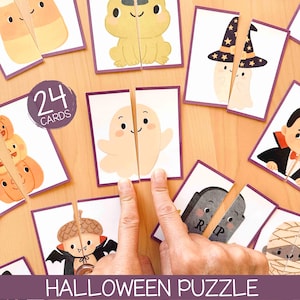 Może przedstawiać: Zestaw 24 kart do układanki na Halloween z ilustracjami duchów, dyń, wampira, mumii i nagrobka z napisem 24 CARDS oraz HALLOWEEN PUZZLE. Każda prostokątna karta jest podzielona na dwie części z fioletowymi obwódkami.