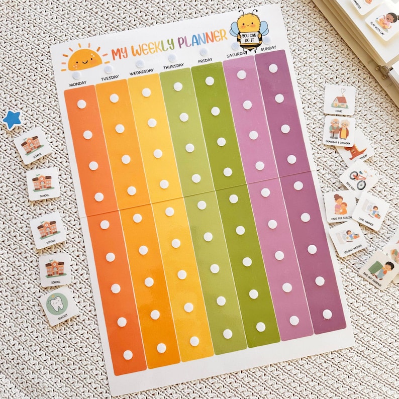 May include: A colorful weekly planner with the text "MY WEEKLY PLANNER" and a smiling sun illustration. The planner has columns for each day of the week, with white dots for attaching activity markers. Includes activity markers with illustrations.