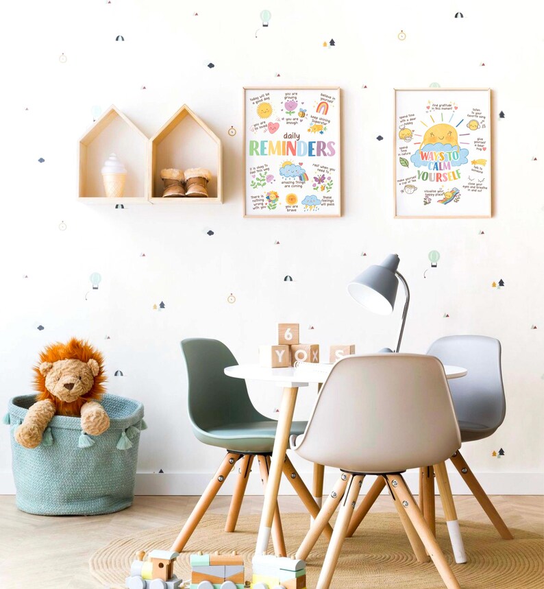 May include: A white table with two chairs and a light fixture. The table is decorated with wooden blocks that spell out "YOX". There are two framed posters on the wall behind the table. The poster on the left says "daily reminders" and the poster on the right says "ways to calm yourself".