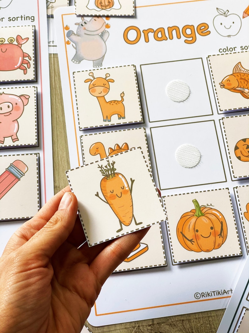 Puede incluir: Un conjunto de tarjetas de clasificaci&oacute;n de color naranja con im&aacute;genes de una jirafa, una zanahoria, una calabaza, un pez, un hipop&oacute;tamo y un fantasma. Las tarjetas est&aacute;n dise&ntilde;adas para que los ni&ntilde;os aprendan sobre los colores y los objetos.