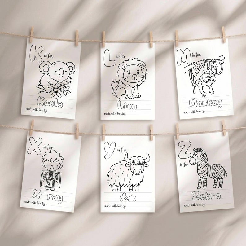 May include: Six white rectangular coloring pages hanging on a string, each featuring a letter of the alphabet, a corresponding animal or object illustration, and the text "is for" and "made with love by". The letters shown are K, L, M, X, Y, and Z.