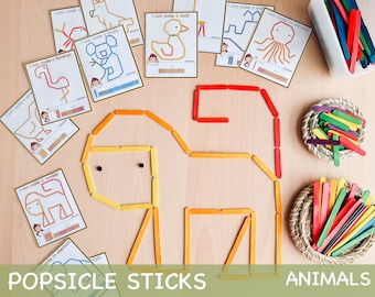Puede incluir: Un conjunto de tarjetas imprimibles con instrucciones para hacer diferentes animales usando palitos de helado. Las tarjetas presentan ilustraciones de un flamenco, un pato, un pulpo, un koala, un mono y un elefante. Las tarjetas también incluyen la cantidad de palitos de helado necesarios para hacer cada animal. La imagen también muestra un animal de palitos de helado terminado, un mono y dos cestas de palitos de helado de colores.