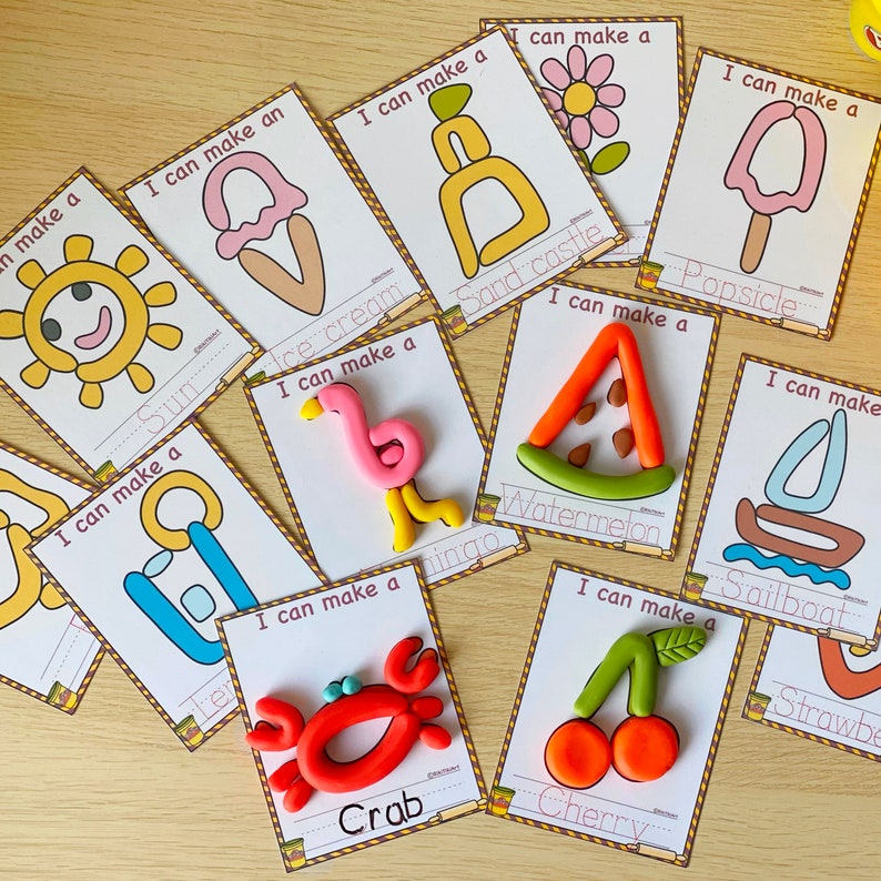 May include: A set of ten colorful flashcards with images of various objects, such as a sun, ice cream, sandcastle, popsicle, watermelon, flamingo, crab, cherry, sailboat, and a lemon. Each card has the text "I can make a" and the name of the object below the image.