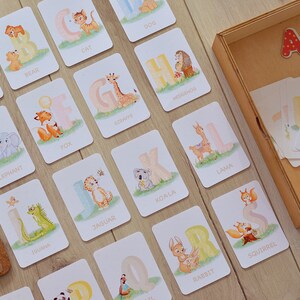 May include: A set of alphabet flash cards featuring colorful illustrations of animals. Each card has a letter of the alphabet and a corresponding animal name. The cards are designed for children learning their ABCs.