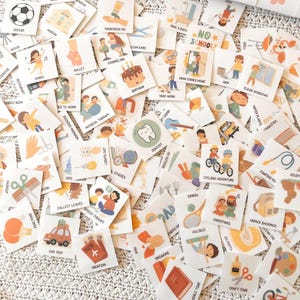 May include: A selection of small, square cards displaying illustrations and text. The cards depict everyday activities, including "Soccer," "Birthday," "Cycling Adventure," and "Vacation." The cards are scattered across a textured surface, offering a glimpse into daily life.
