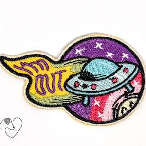 May include: An embroidered patch with a purple, pink, and yellow background. A blue and white UFO is flying away from a yellow banner with the text "I'm Out".